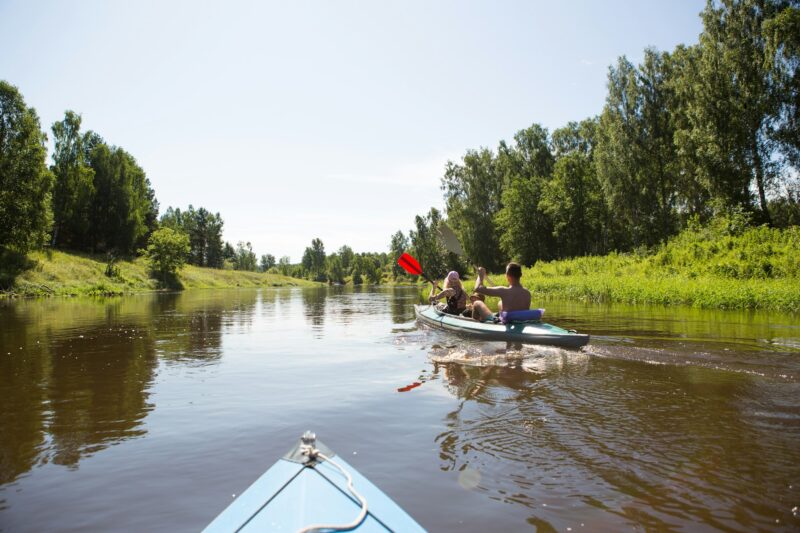A couple of men and women kayak on the river in the summer. Active recreation, family travel, extrem