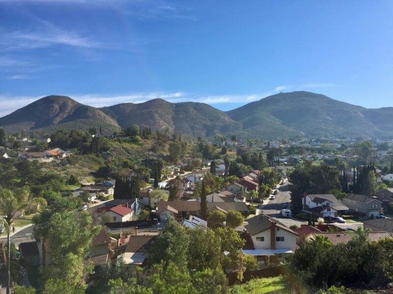A sunny day on a beautiful suburban neighborhood with mountains, houses and trees