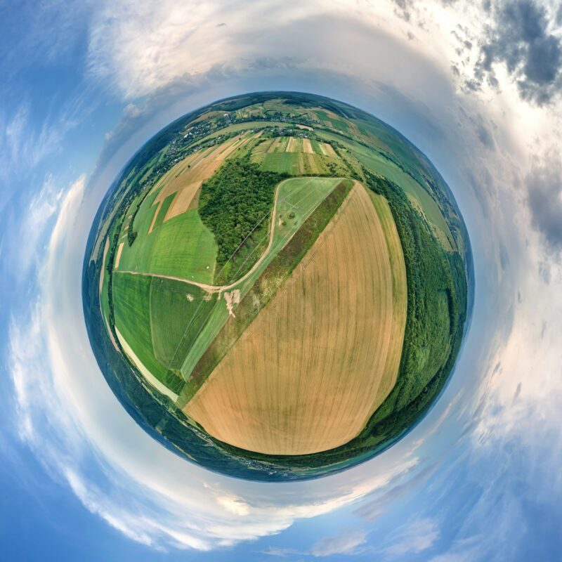 Aerial view from high altitude of little planet earth with yellow cultivated agricultural fields