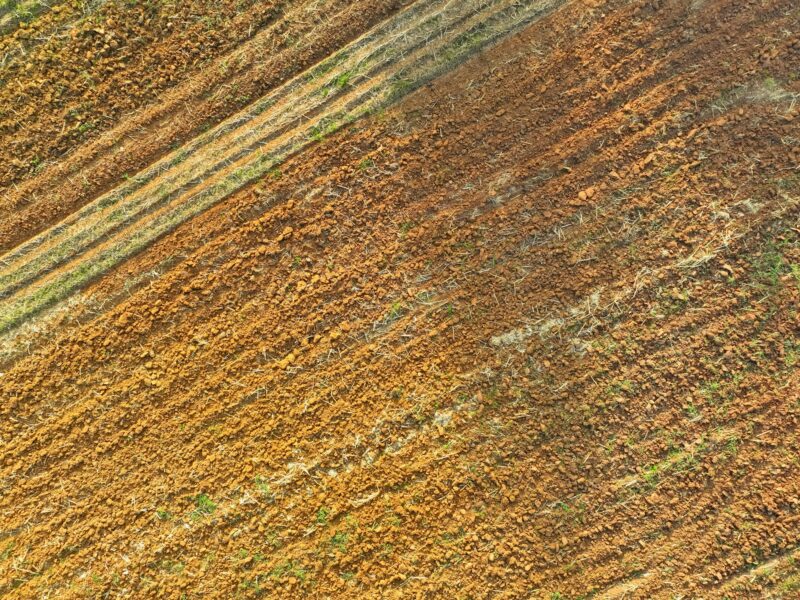 Aerial view of agriculture plowed field. Minimal tillage for healthier soils. Fertile soil