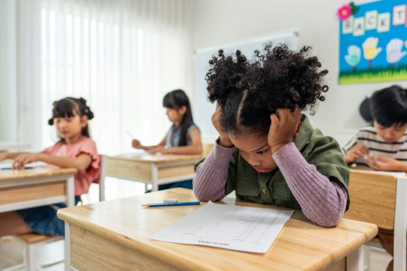 African American black girl student doing an exam at elementary school.