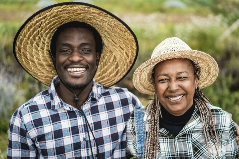 African american farmers smiling on camera during harvest period - Focus on faces