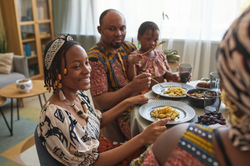 African family in traditional costumes having holiday dinner