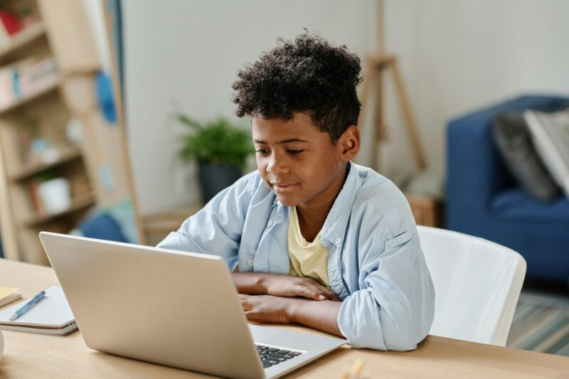 African schoolboy using laptop for online education