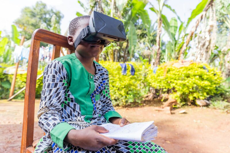 An African child does homework using an augmented reality viewer, technology in education in Africa