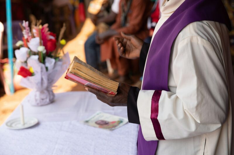 an African priest carries out mass and reads the bible during the celebration