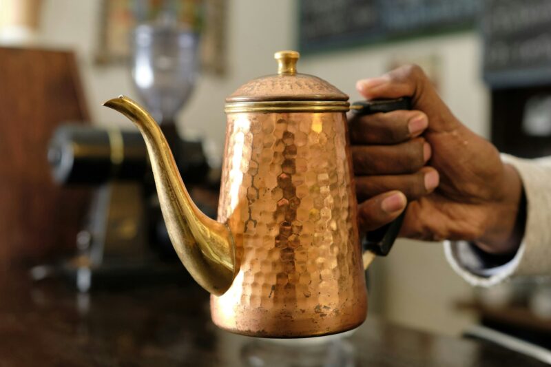 An Ethiopian with a copper coffee pot in hand