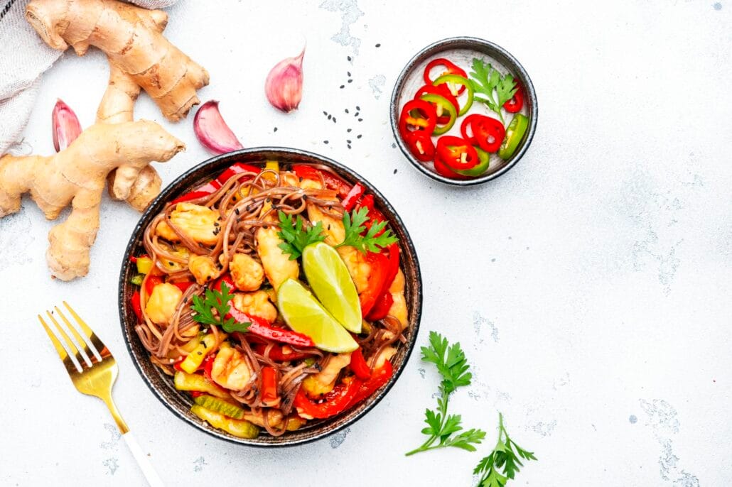 Asian cuisine, stir fry noodles with chicken and vegetables, red paprika and zucchini, sesame seed