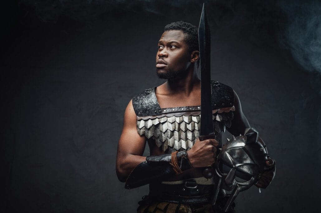 Authentic roman gladiator stares to camera on gray background