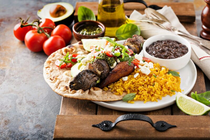 Beef kebab with rice, beans and fried plantains