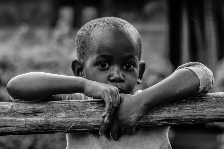 Black and White of an African boy leaning on a tree