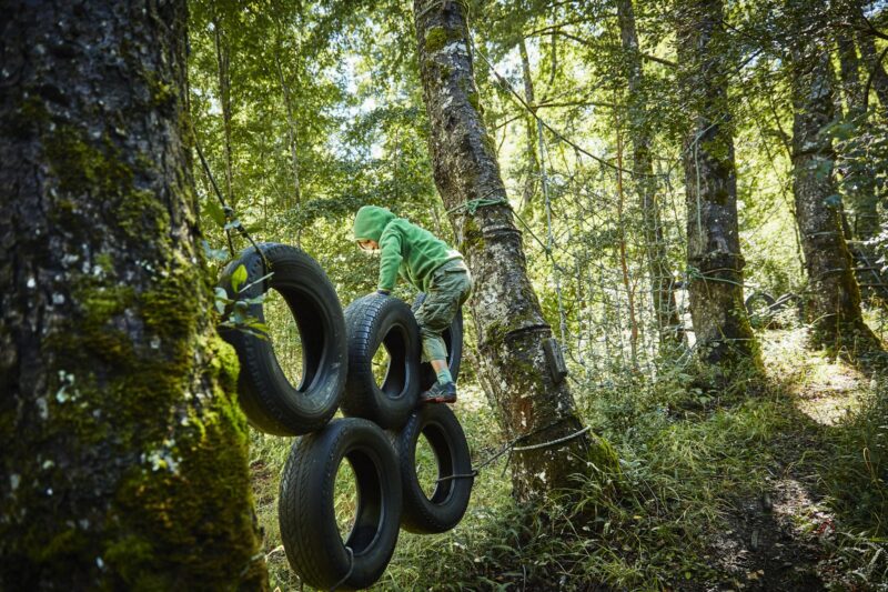 Boy balancing on tyres at an adventure park in forest