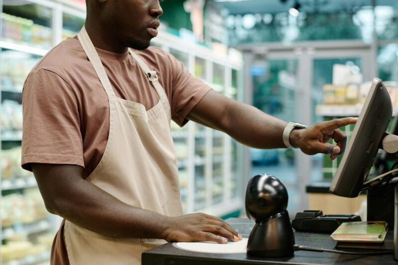 Cashier working on computer in supermarket