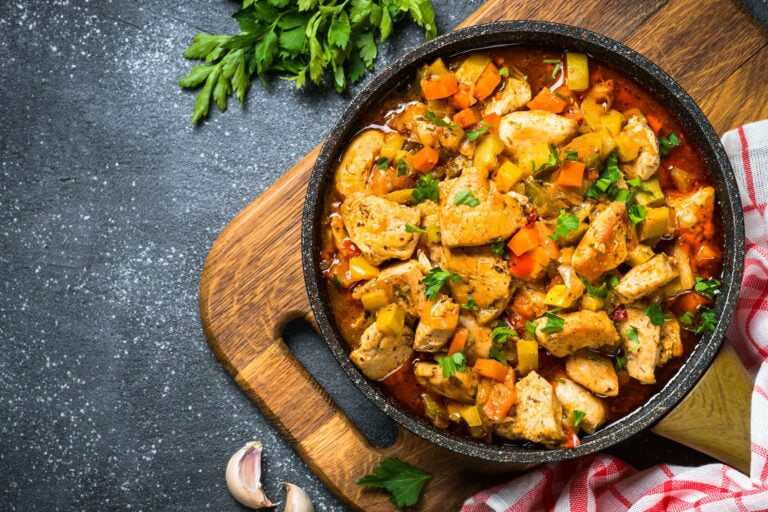 Chicken stew with vegetables black stone table, top view