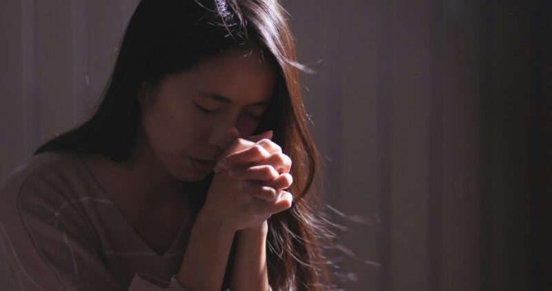 Christian women praying in the dark