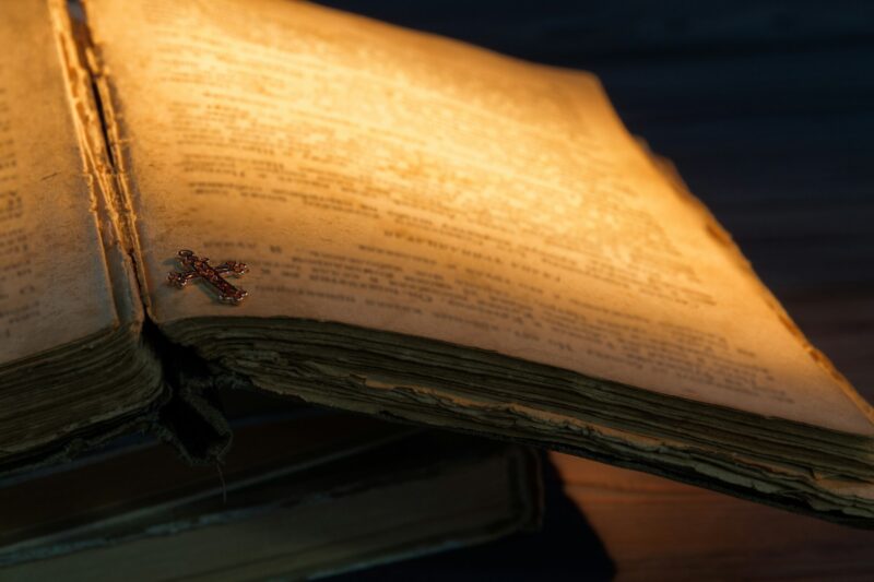 Close-up golden christian cross on an old book.
