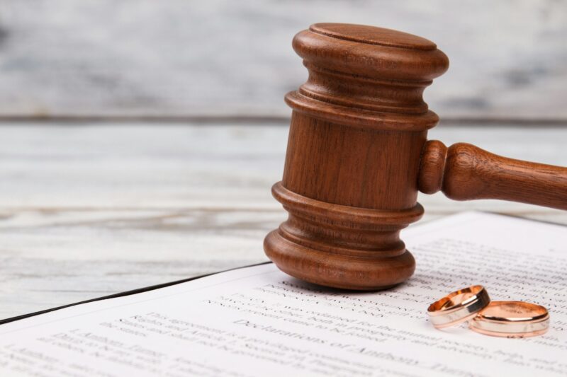 Close-up judge gavel and wedding rings.