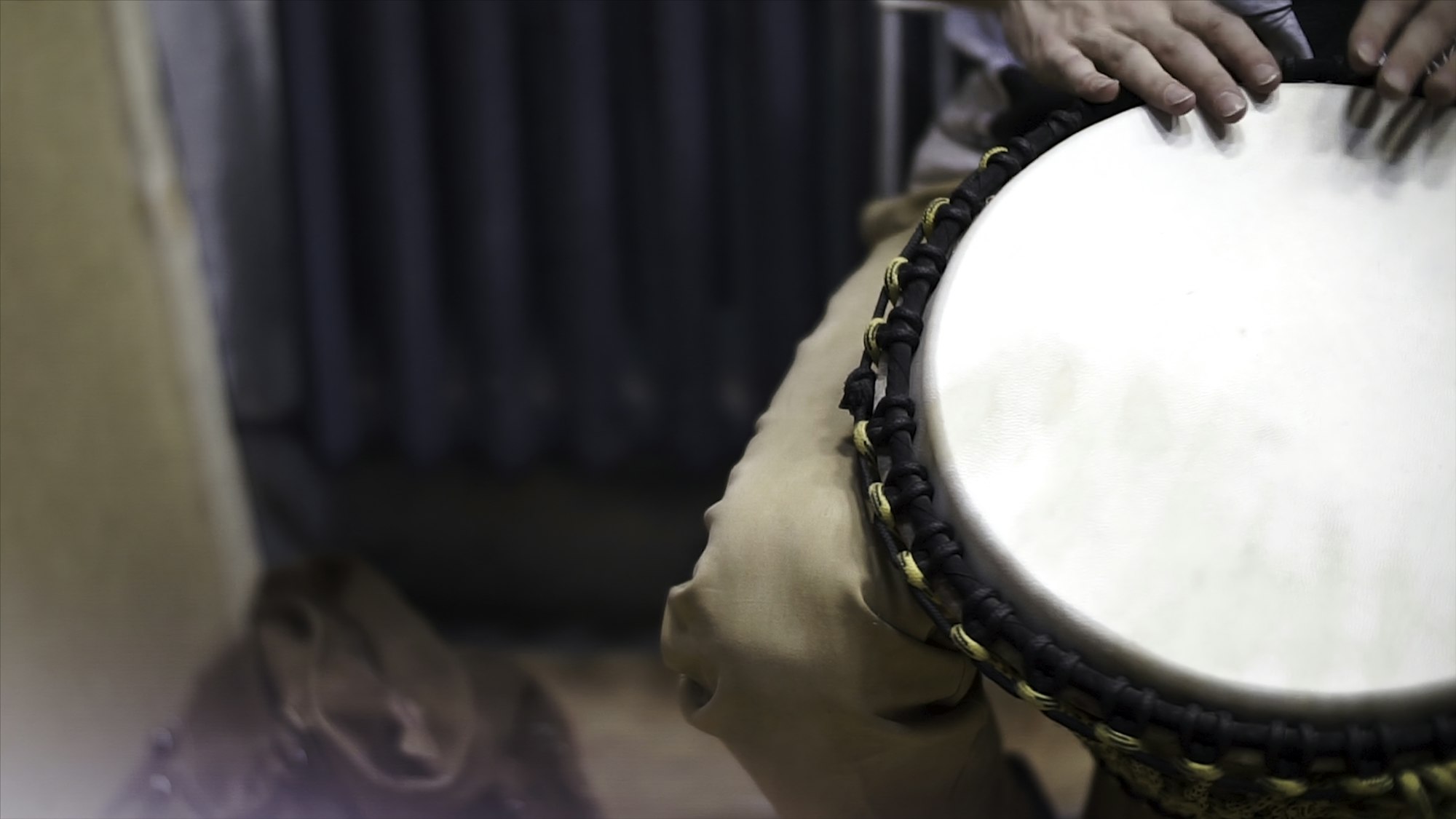 Close up of hands of a black man playing a drum. Clip. Drummer plays on small African drum, closeup