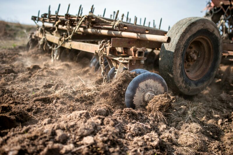 close-up of tractor working the field by plowing and cultivating