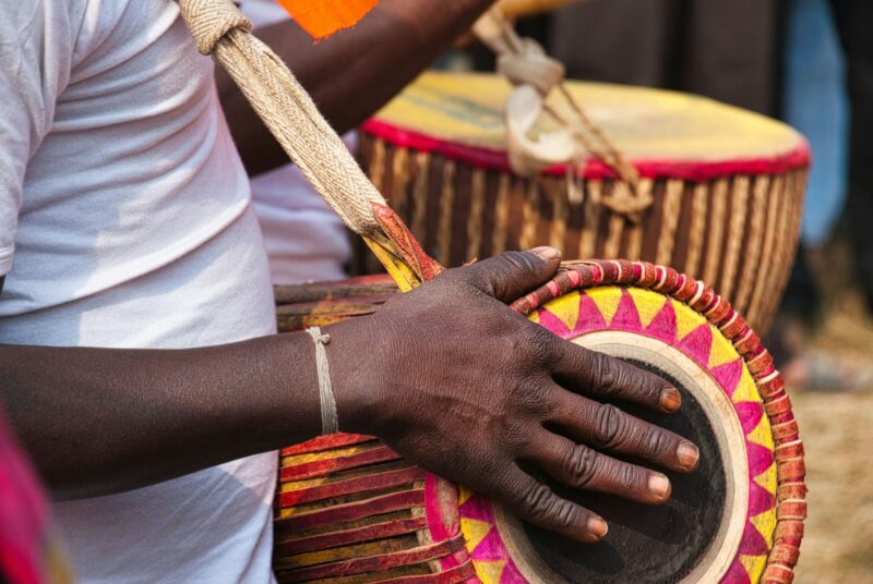 Closeup of a tribal man playing a local musical instrument at a folk festival in West Bengal.