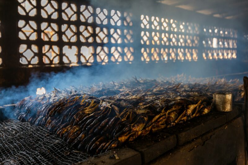 Closeup of grilled fish with metallic windows on the background in the Gambia