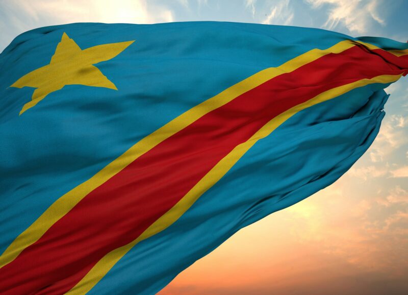 Closeup view of the flag of the Democratic Republic of the Congo on a background of sunset