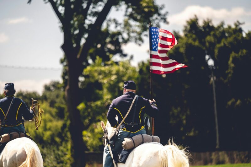 Confederate reenactor riding a horse with a flag of the United States at the Civil War reenactment