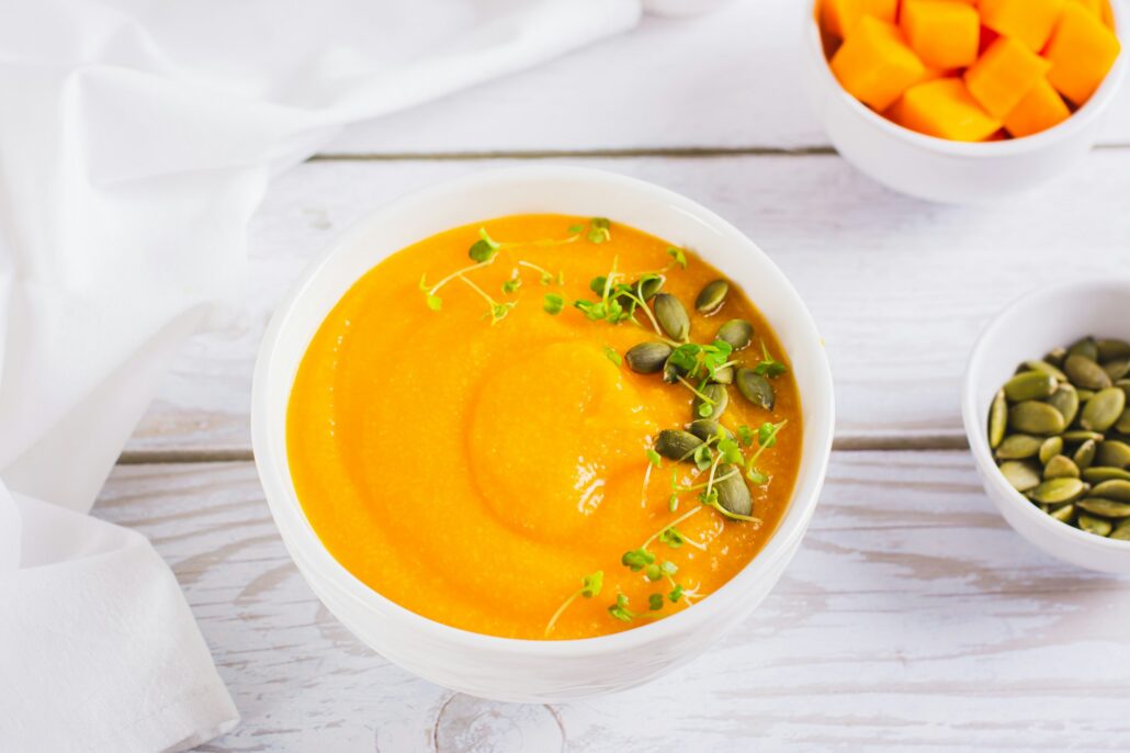 Corn porridge with pumpkin puree and microgreens in a bowl on the table