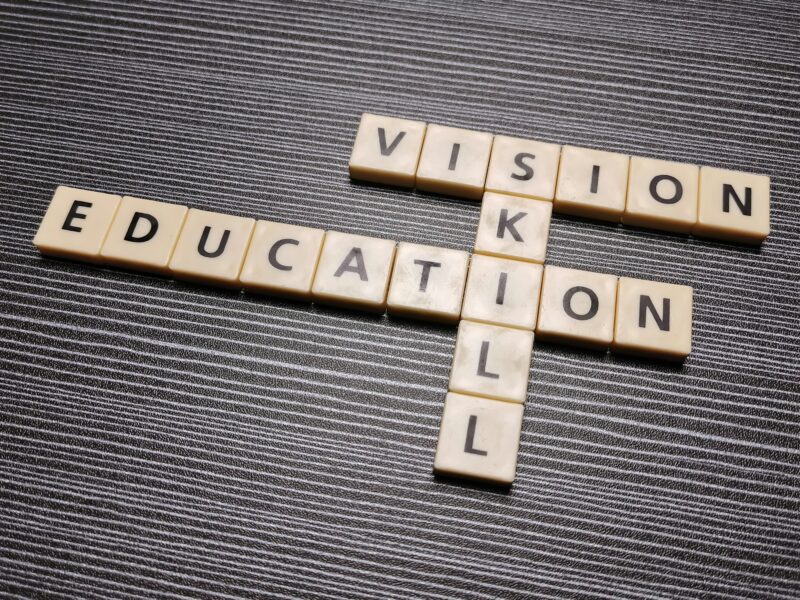 Crossword education skill vision made from square letter tiles against black background.