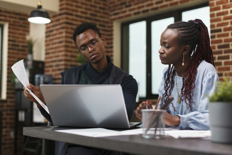 Development agency office workers reviewing accounting documents and strategy solutions.