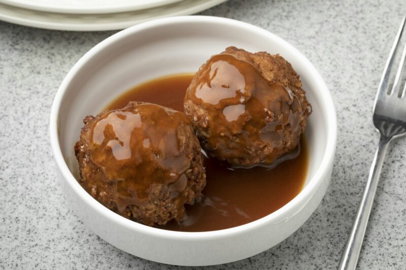 Dish with traditional Dutch baked meatball and sauce on the table