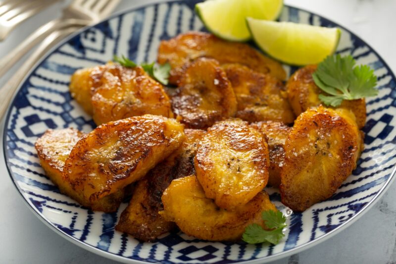 Fried caramelized plantains served with lime wedges