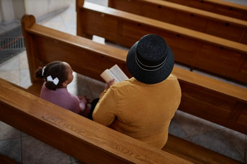 Grandmother teaching christian customs to her granddaughter