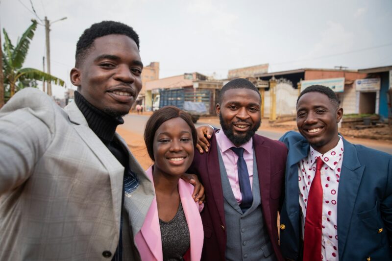 Group of friends take a selfie together, well-dressed African young adults in the city center