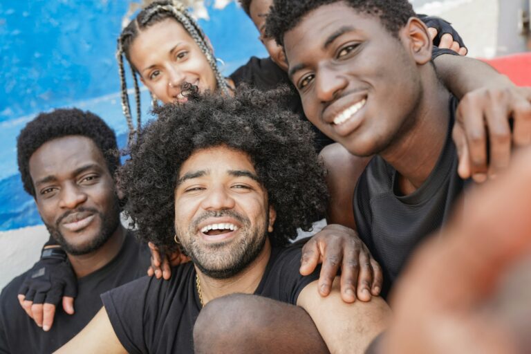 Group of multiracial friends taking a selfie outdoor - Young people looking on camera in the city