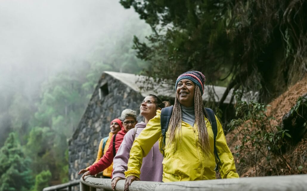 Group of women with different ages and ethnicities having fun walking in foggy forest