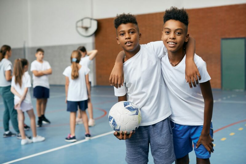 Happy African American boys having physical education class at school gym.