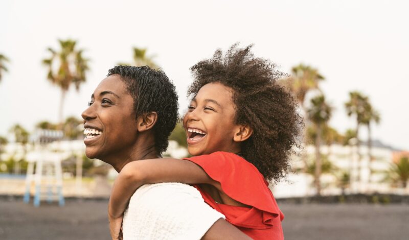 Happy African family on the beach during summer holidays