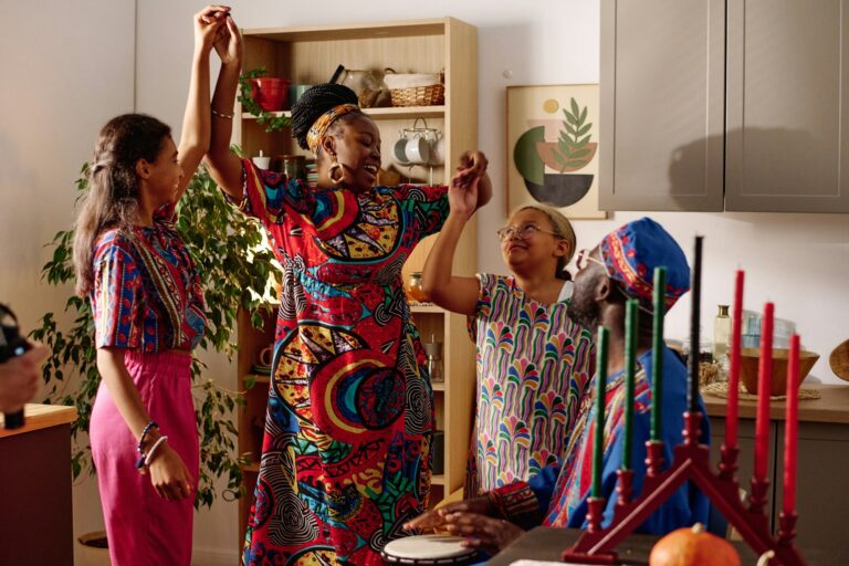 Happy mother and two daughters holding by hands and dancing