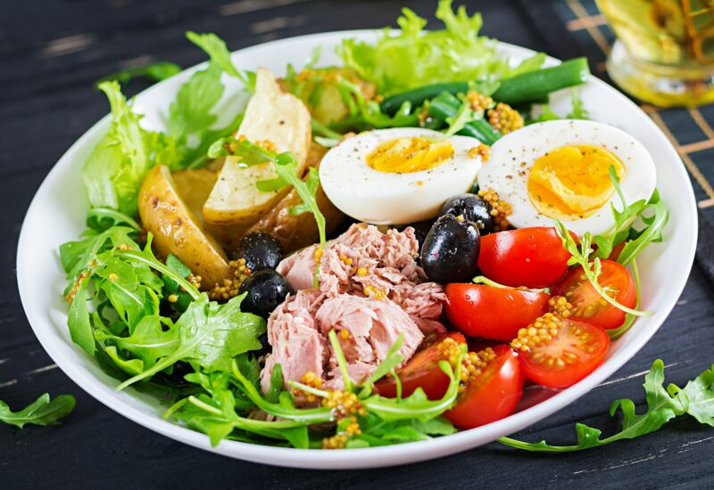 Healthy hearty salad of tuna, green beans, tomatoes, eggs, potatoes, black olives