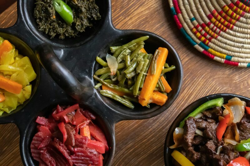 High angle shot of delicious traditional Ethiopian food with vegetables on a wooden surface