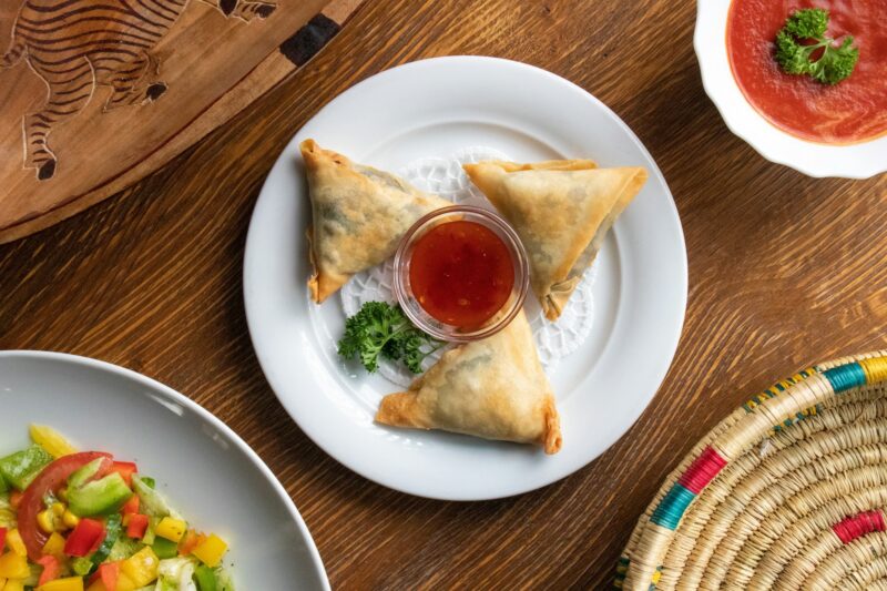 High angle shot of plates of traditional Ethiopian food with vegetables on a wooden surface