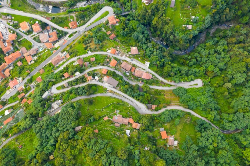 High angle view of houses with red roofs amoung trees on the top of the mountain in summer. Arial