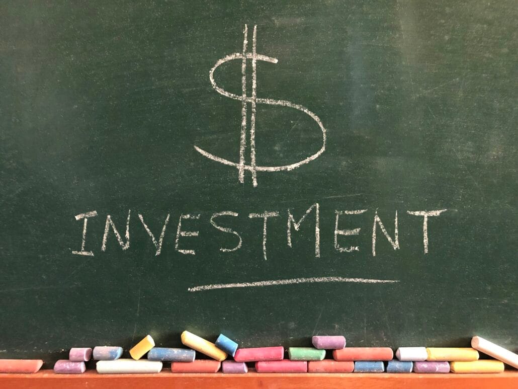 $ investment written on a green chalk board