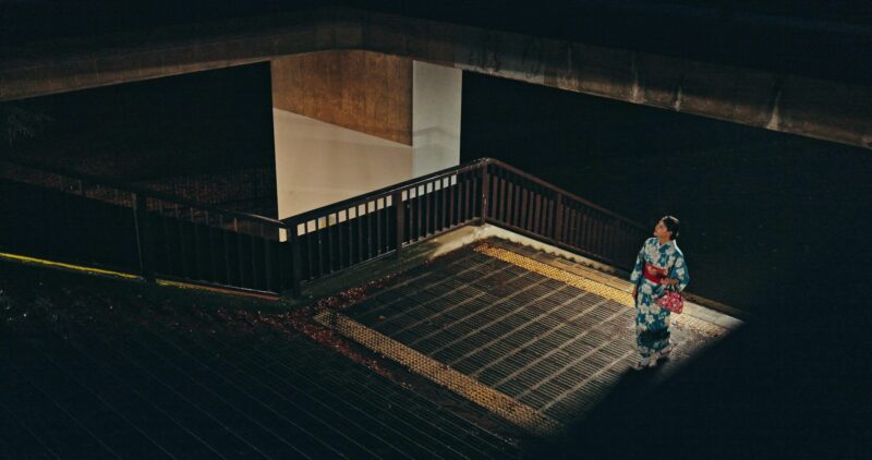 Japanese woman, kimono and culture on stairs at night, city and religion for heritage celebration.