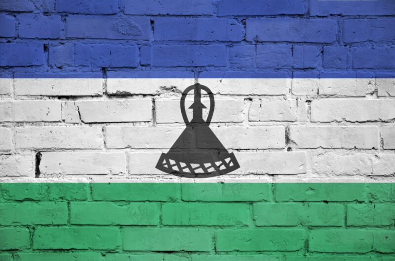 Lesotho flag is painted onto an old brick wall