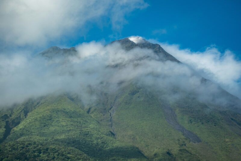 Mountain covered in a cloud of fog under the clear blue sky