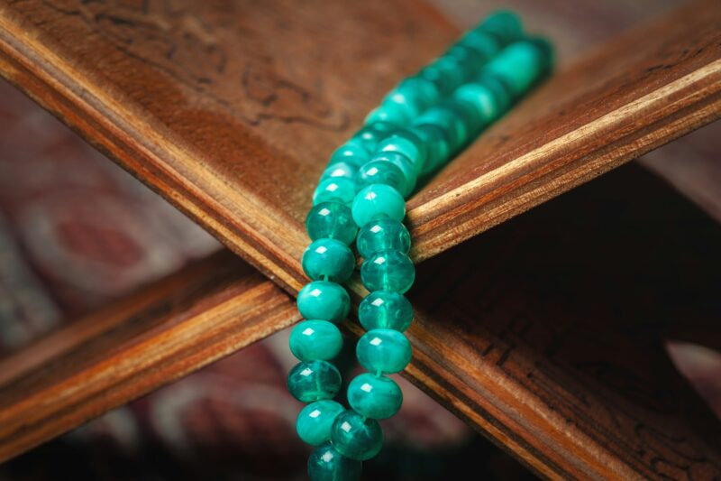Muslim prayer beads on wooden background close up