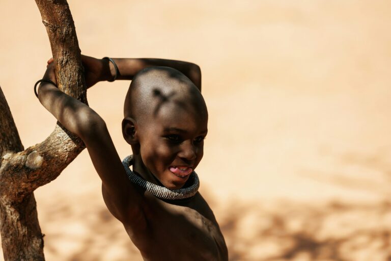 Namibia, Africa - June 14, 2021: Standing near tree. Child of the ethnic people of Africa