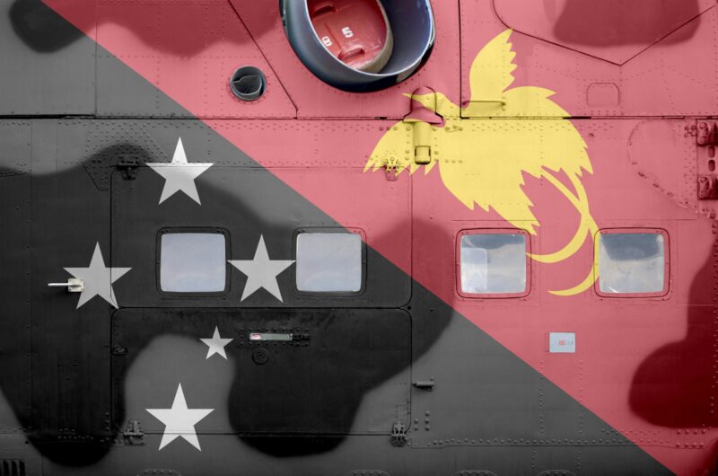 Papua New Guinea flag depicted on side part of military armored helicopter close up